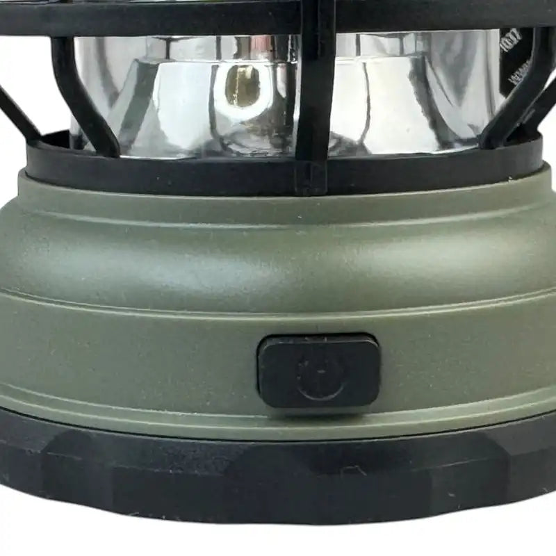 Close-up of a green camping lantern with a black switch