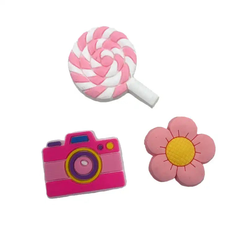 Three pink and white Sippety Charms including a lollipop, camera, and flower 