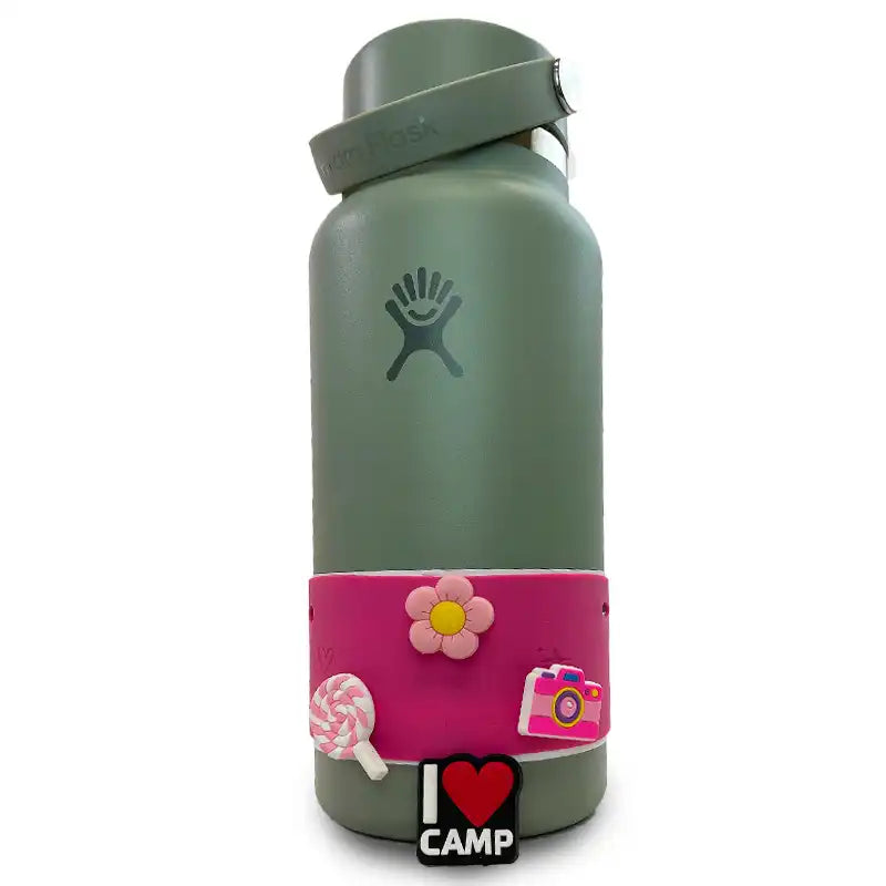 Three pink and white Sippety Charms on a bottle including a lollipop, camera, and flower 