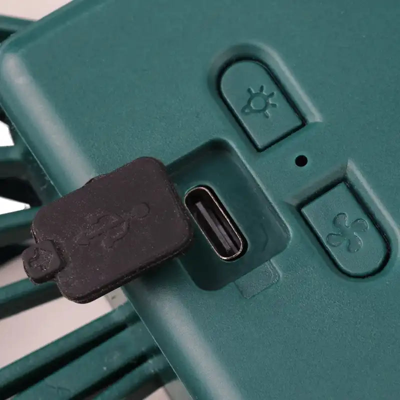 Close-up of a green electronic device with USB-C port and control buttons.